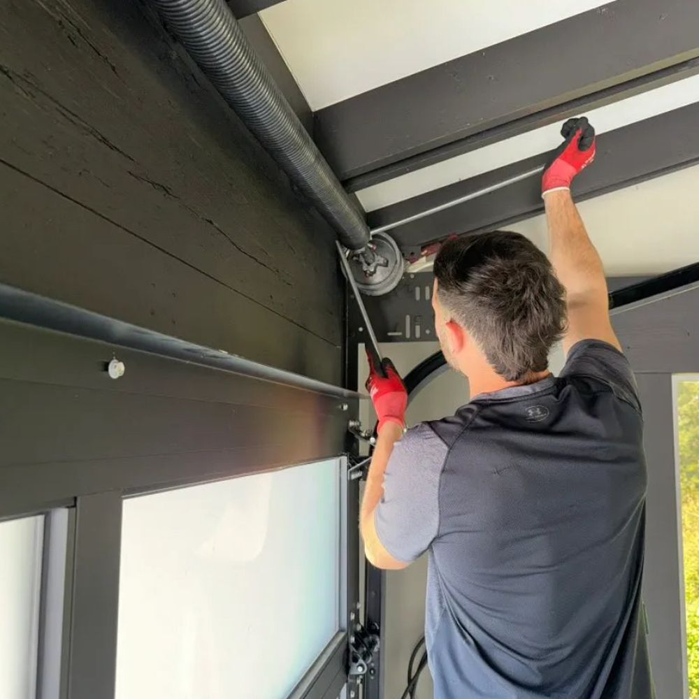 Maxim Garage Door technician repairing a garage door in Dallas